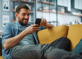 Man on couch holding a smartphone