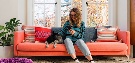 Woman and dog sitting on couch