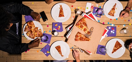 Pizza and party decorations on table