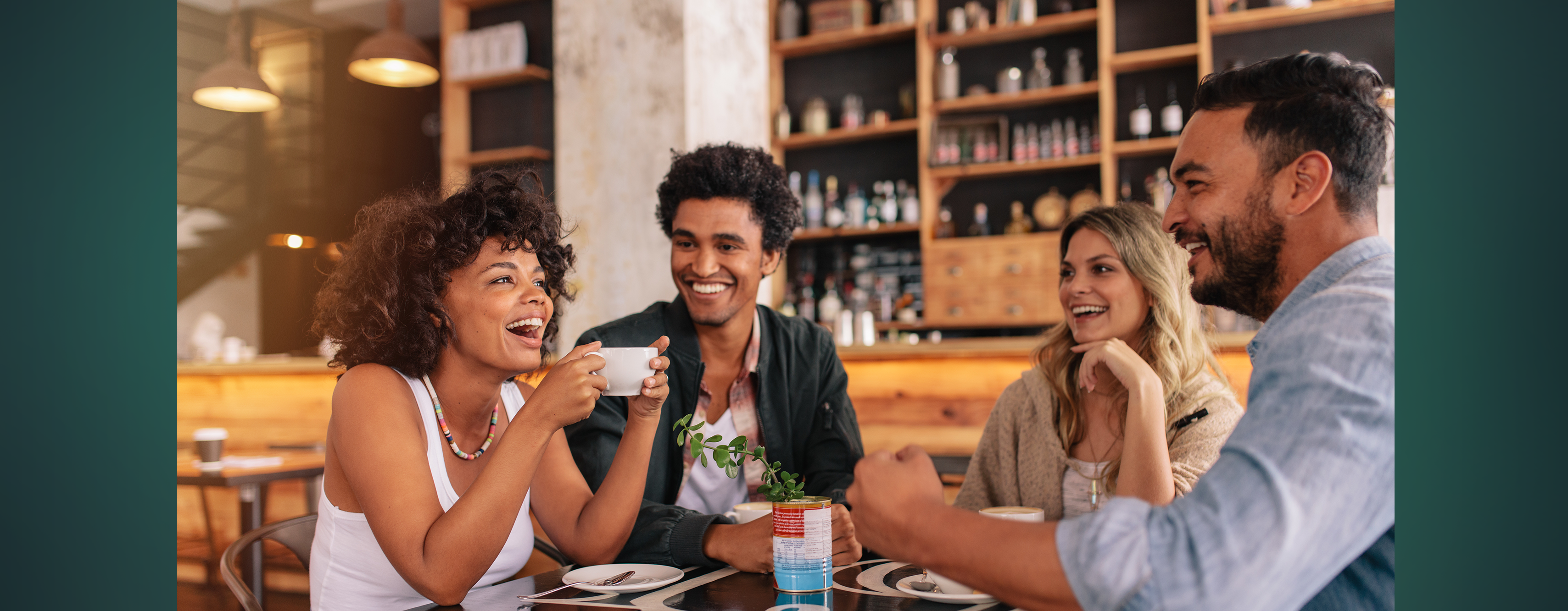 A group of four friends in their twenties to thirties having coffee together in a cafe