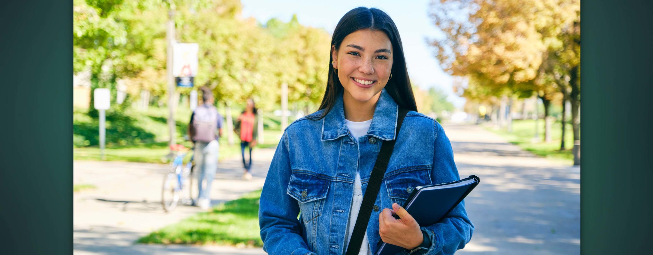 A smiling college student walking on campus