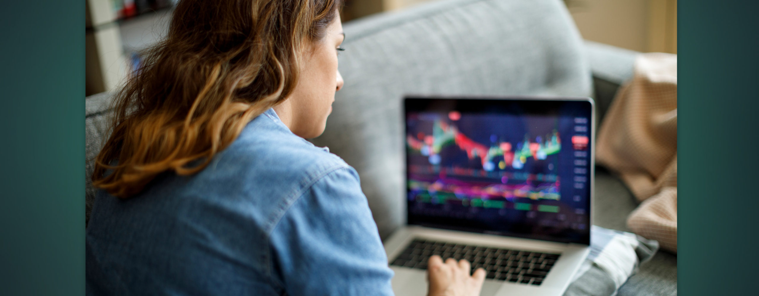 A woman looking at a chart of her investment performance on a laptop