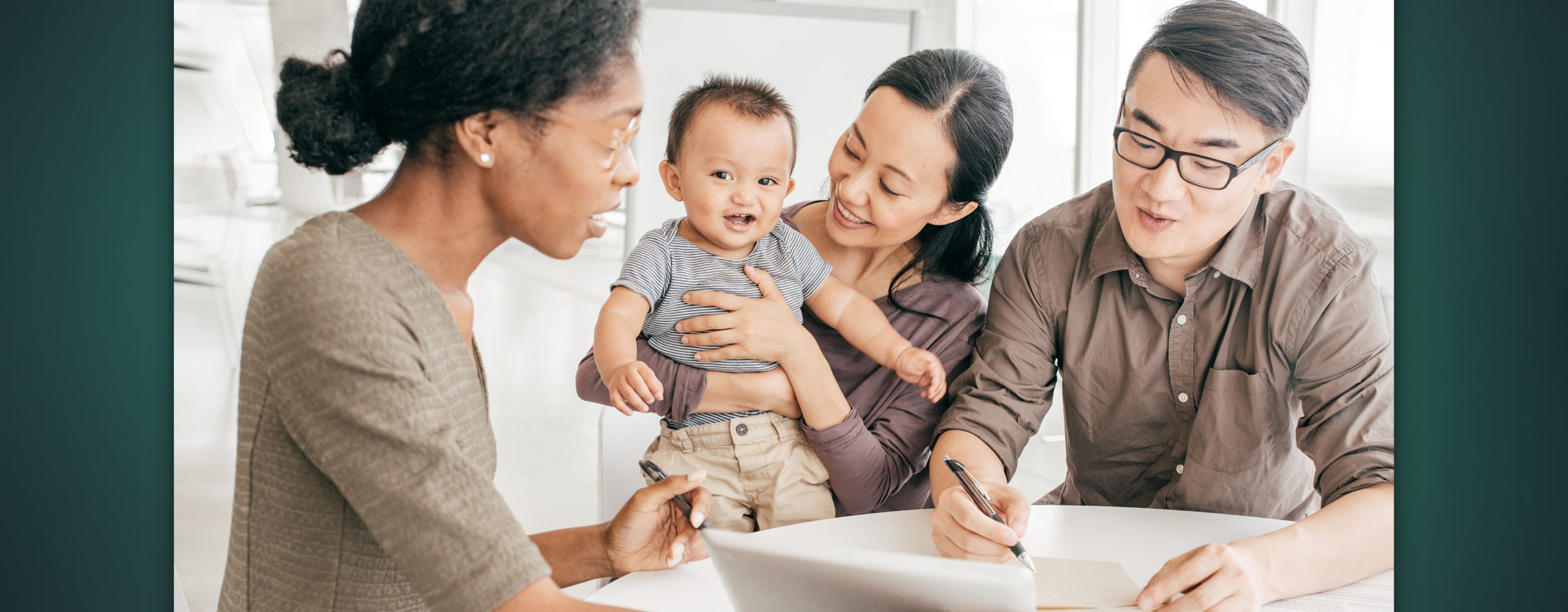 A couple with a young child going over paperwork with a trust officer