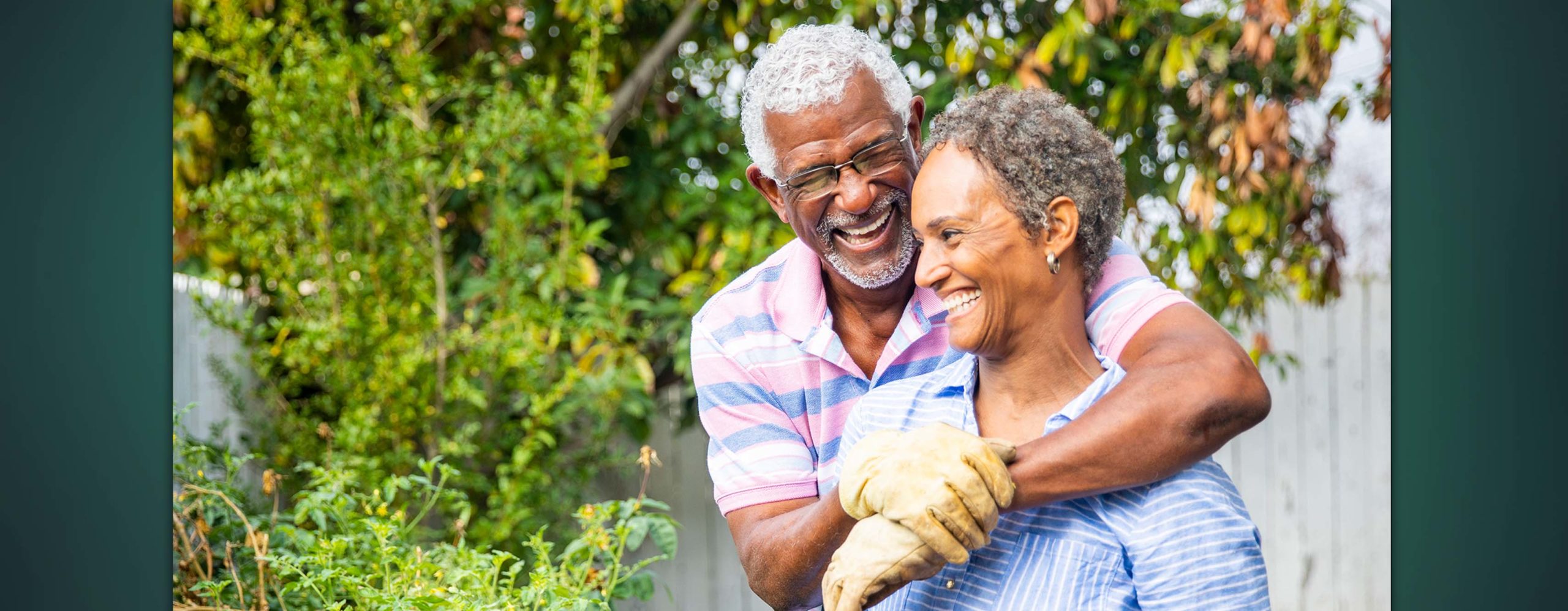 A smiling older couple gardening together