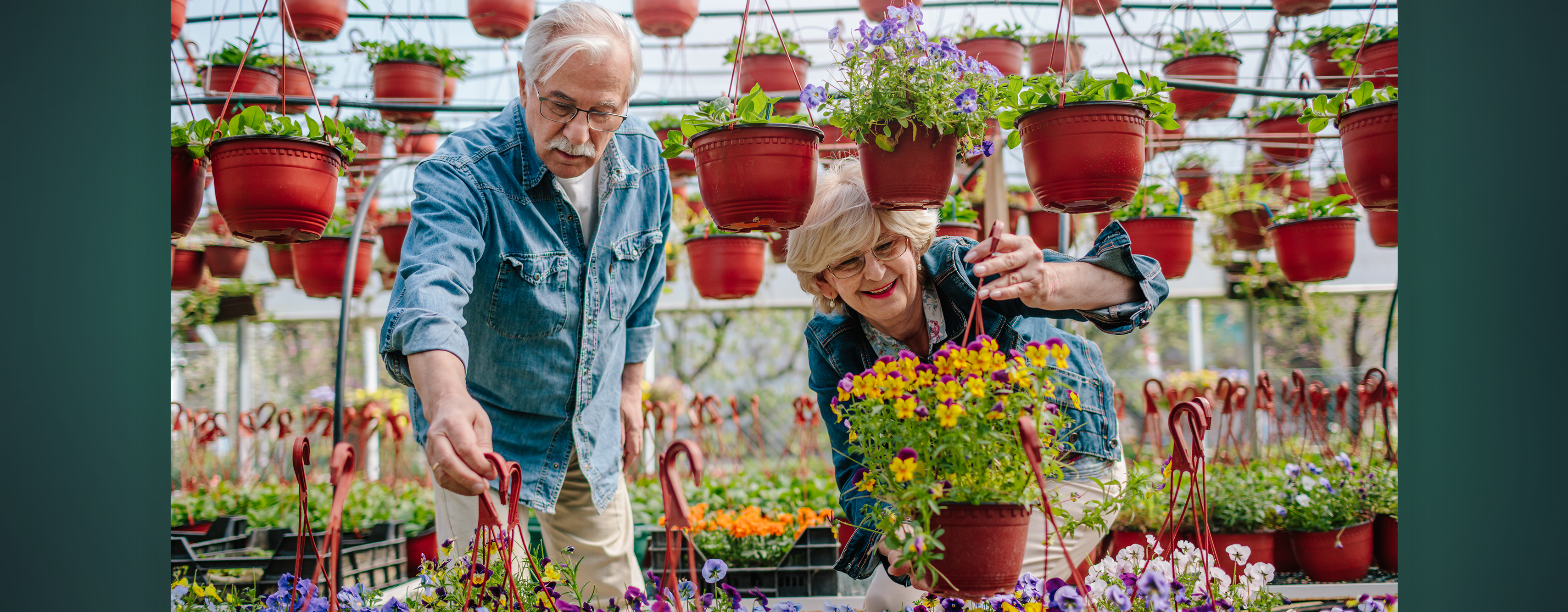 An older couple looking at flowers in a plant shop together