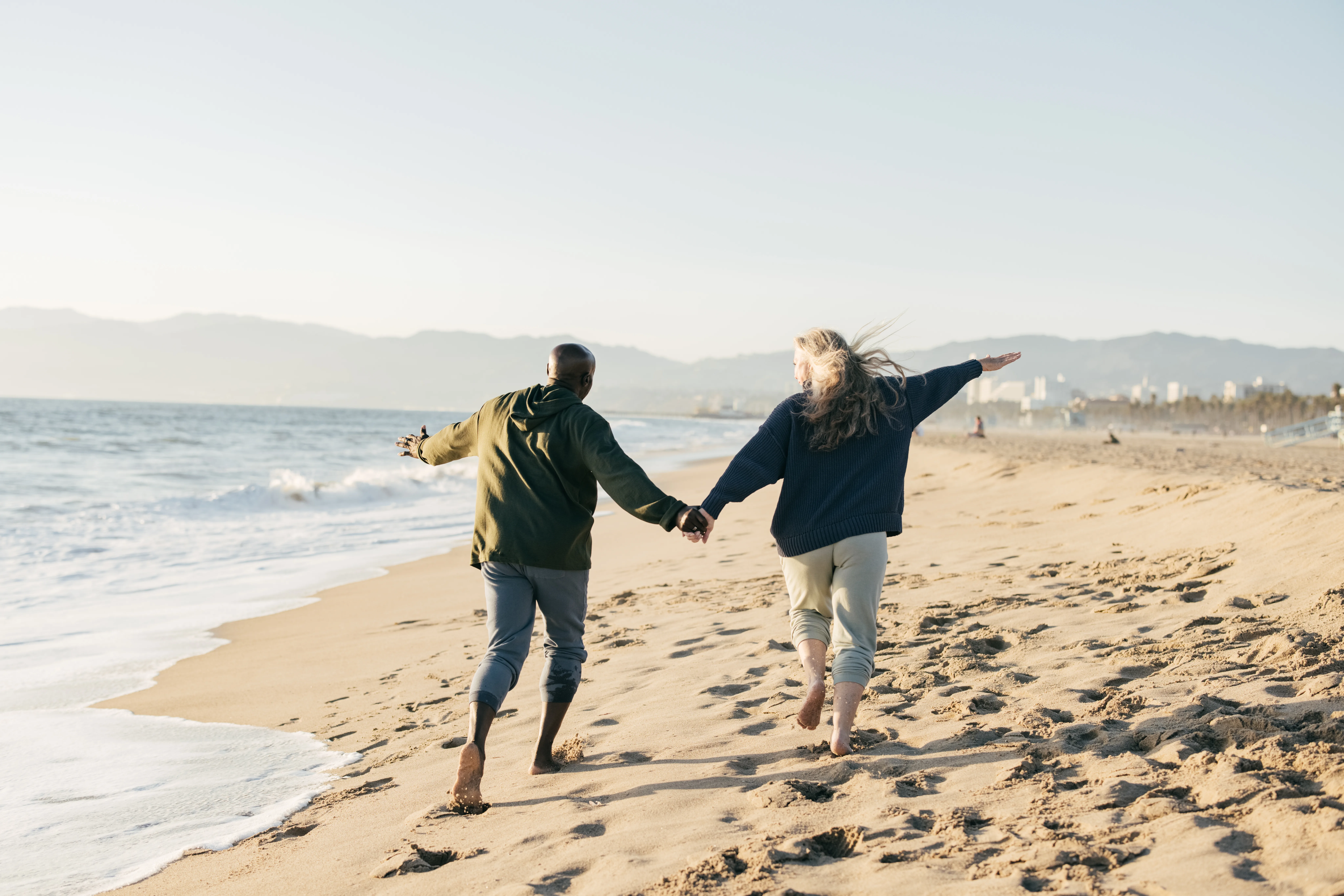 A couple holding hands taking a stroll down the beach