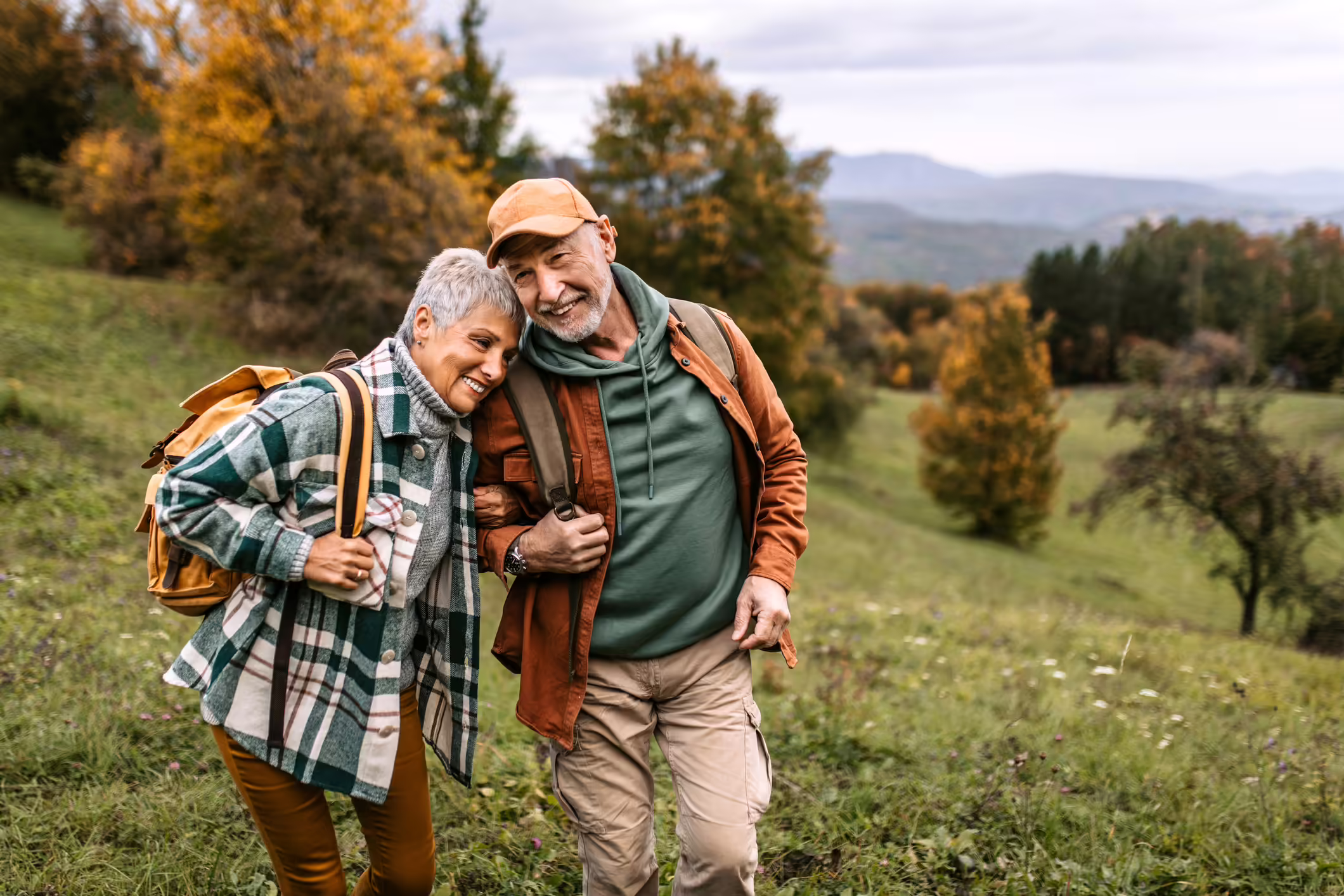 An older couple hiking together in the fall