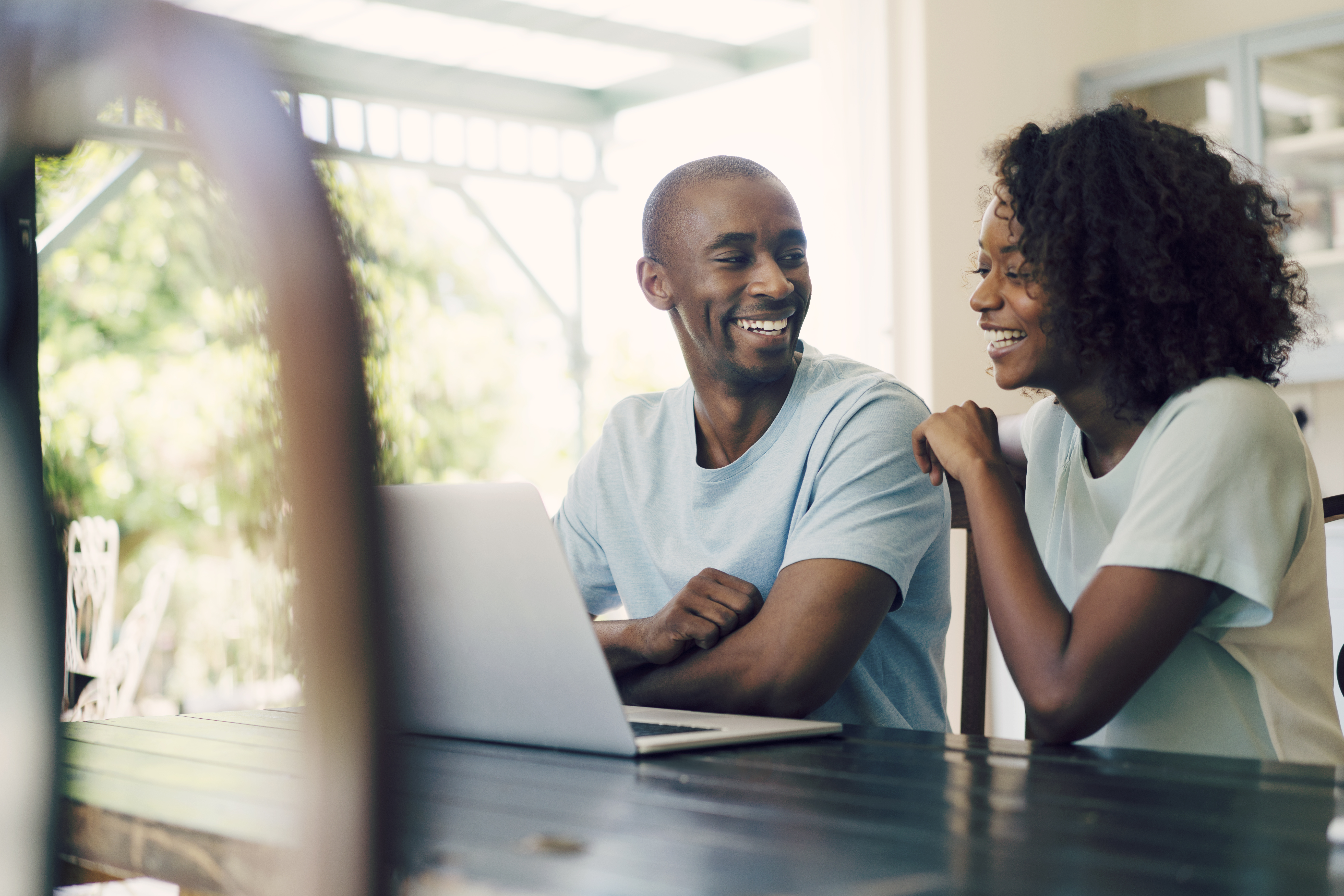 A couple looking at a laptop together and smiling