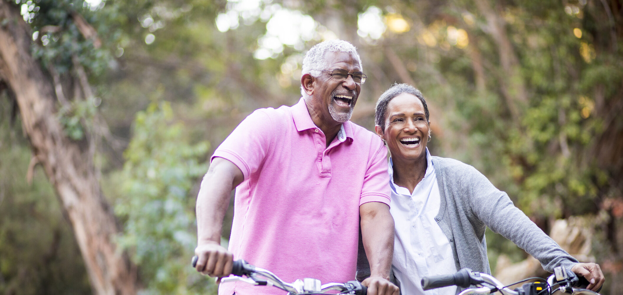 An older couple biking together in a park