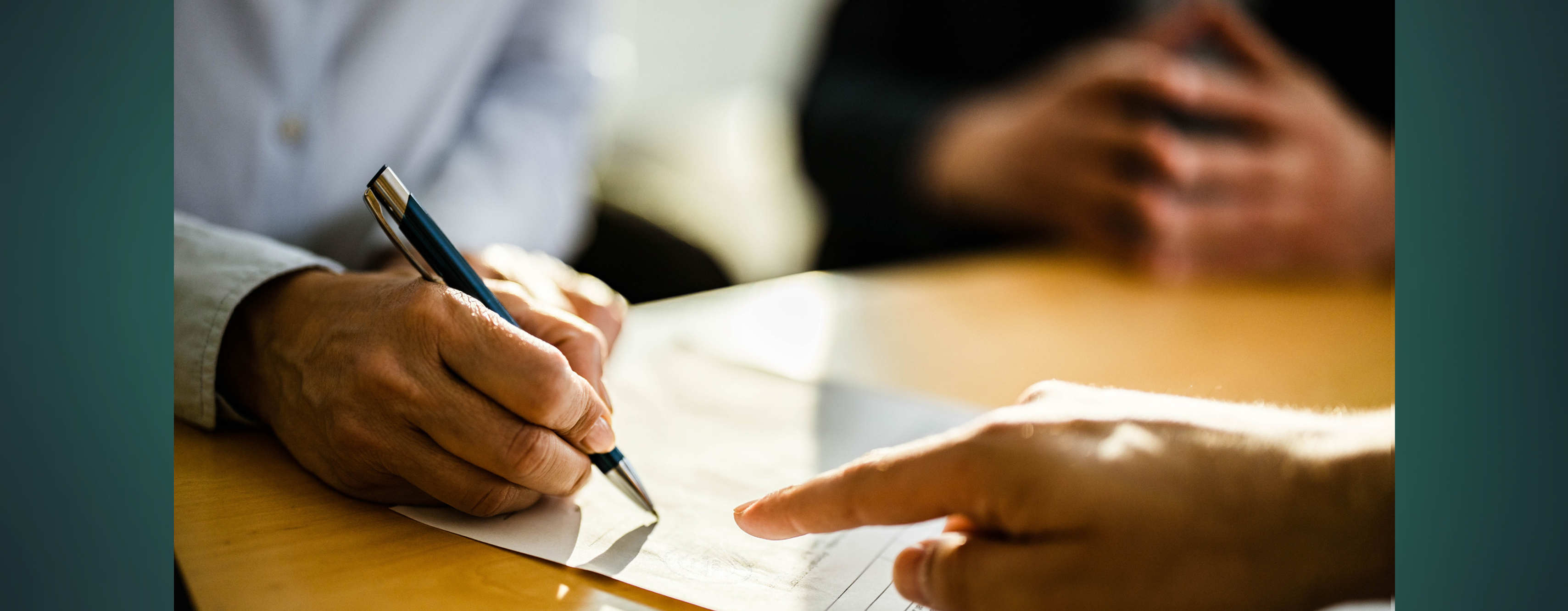 A close up of someone signing a document