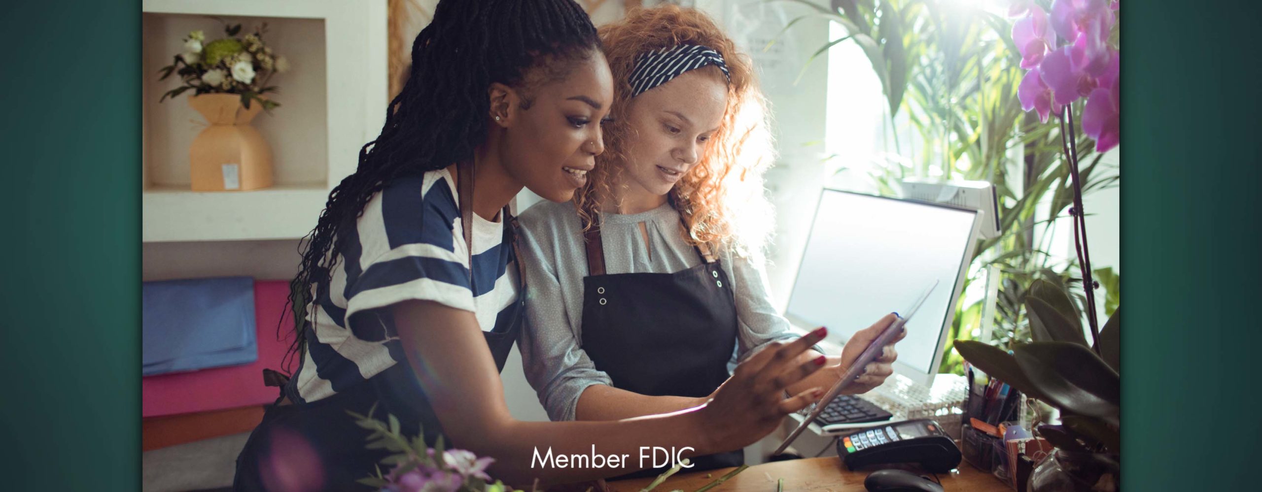 Two women working in a small business looking at a tablet together