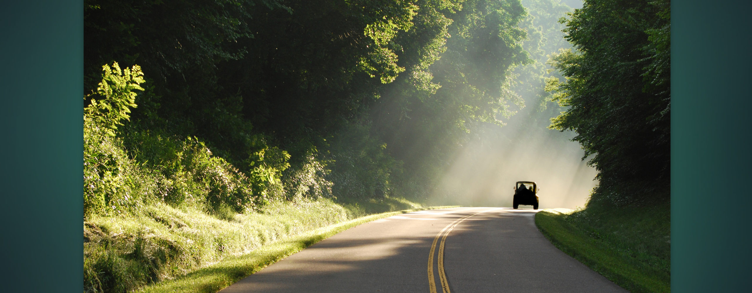 A photo of a jeep driving down a road for a road trip