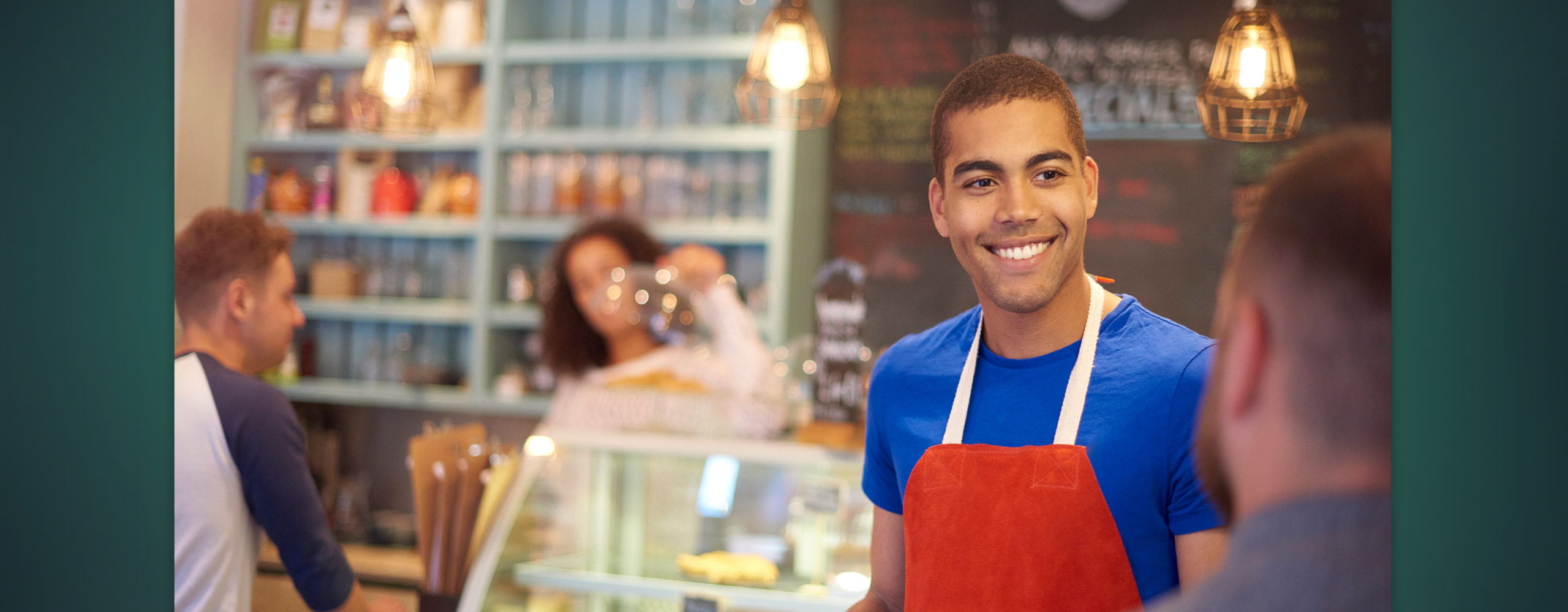 A smiling young man working in a pastry shop
