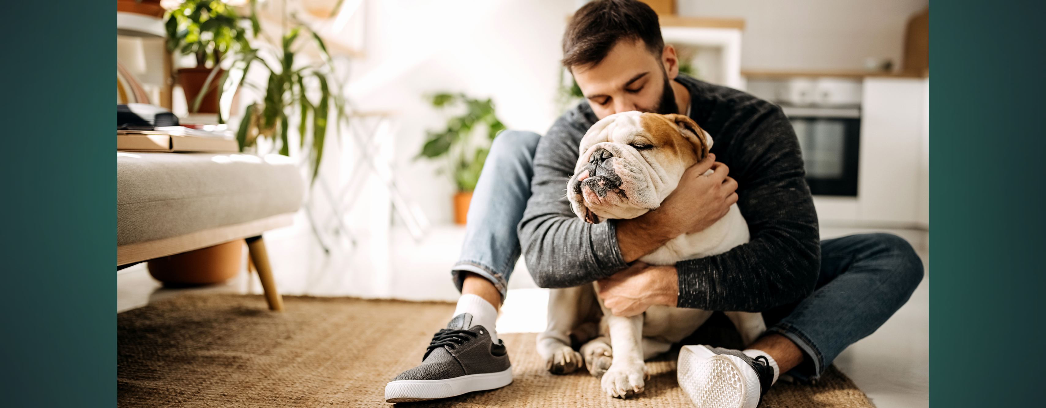 A man hugging his pet bull dog