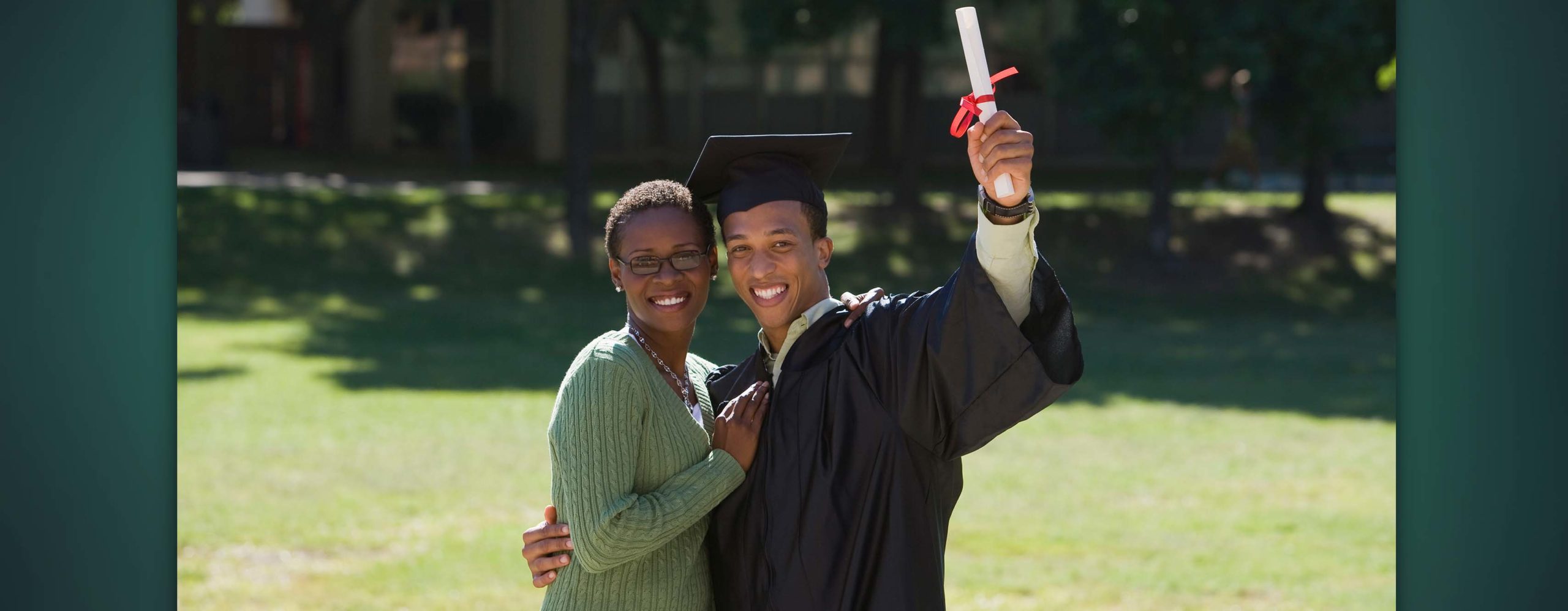 A graduate and family member smiling for a photo