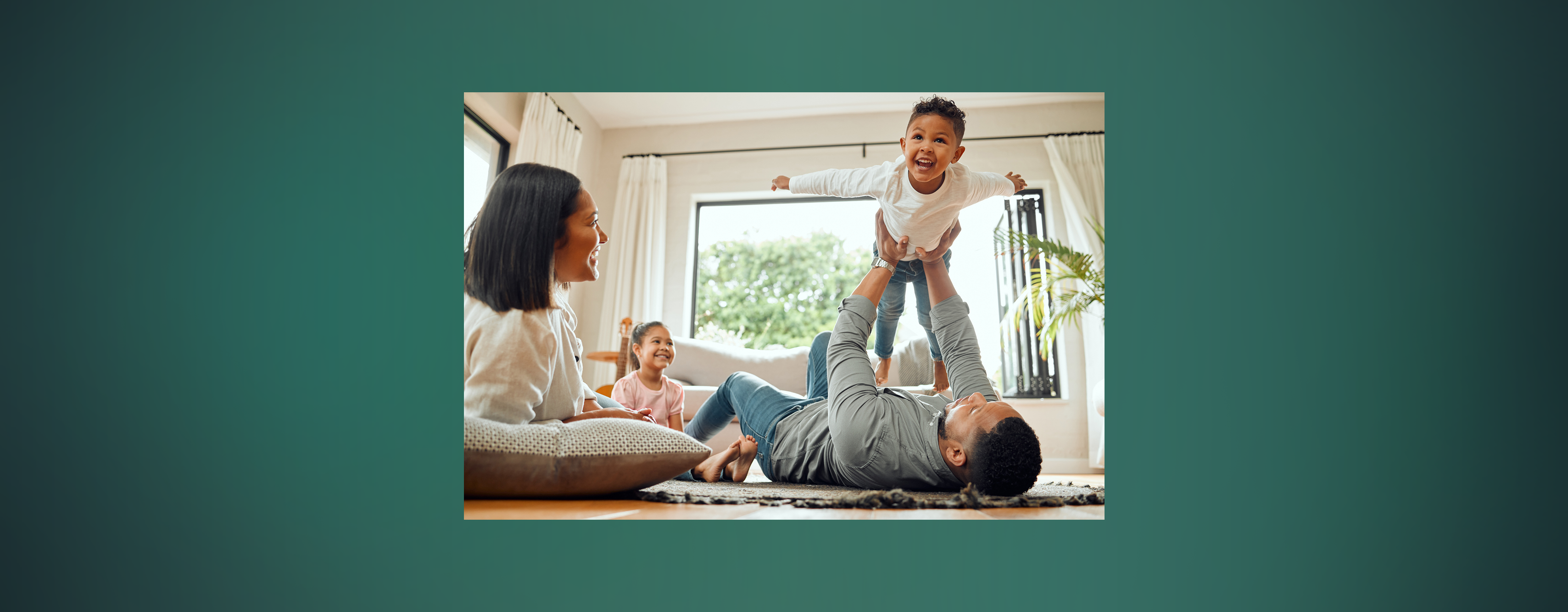 A family with two young kids playing together in the living room