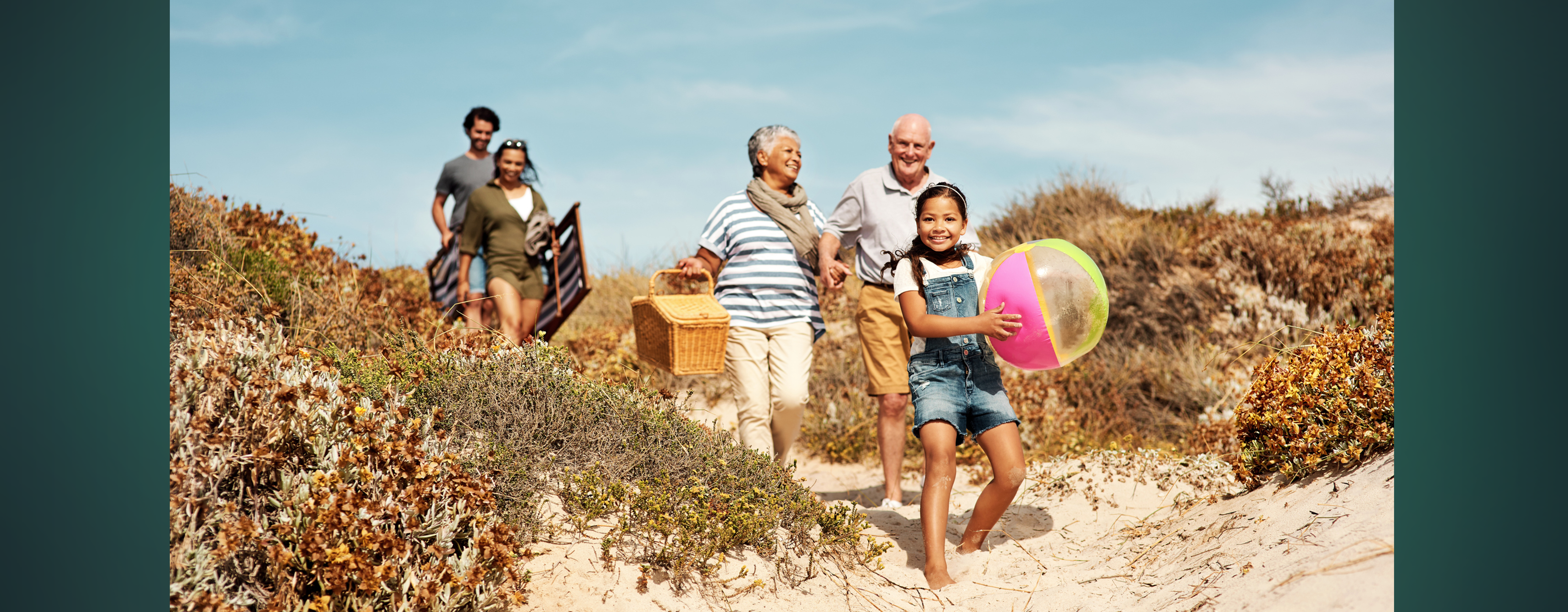 An older couple on a beach vacation with their kids and granddaughter