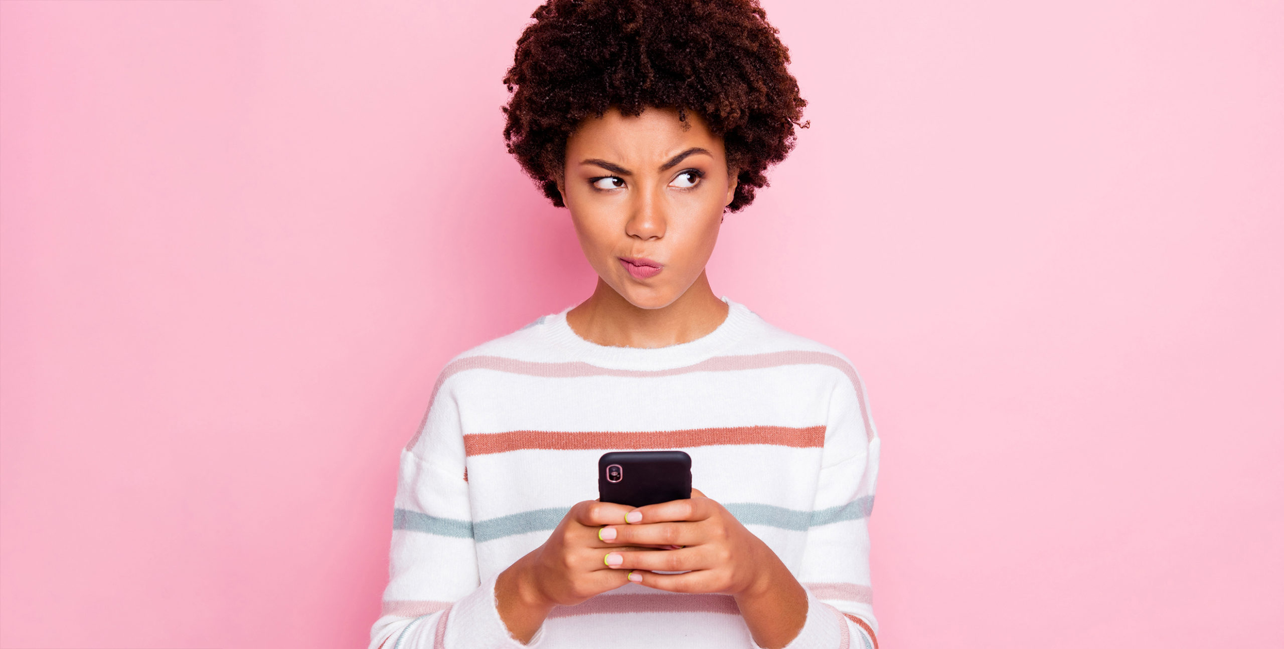 A girl holding a cell phone making a thinking face
